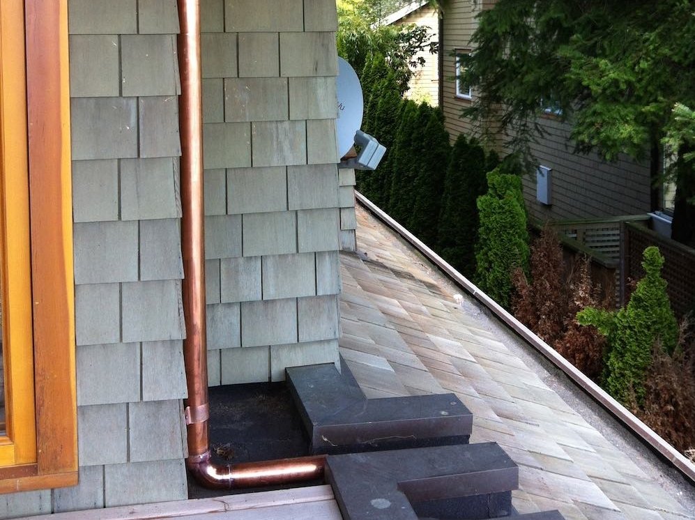 Hidden Gutter Repair | West Vancouver Home: copper downpipes used throughout to drain water from the upper eavestroughs.